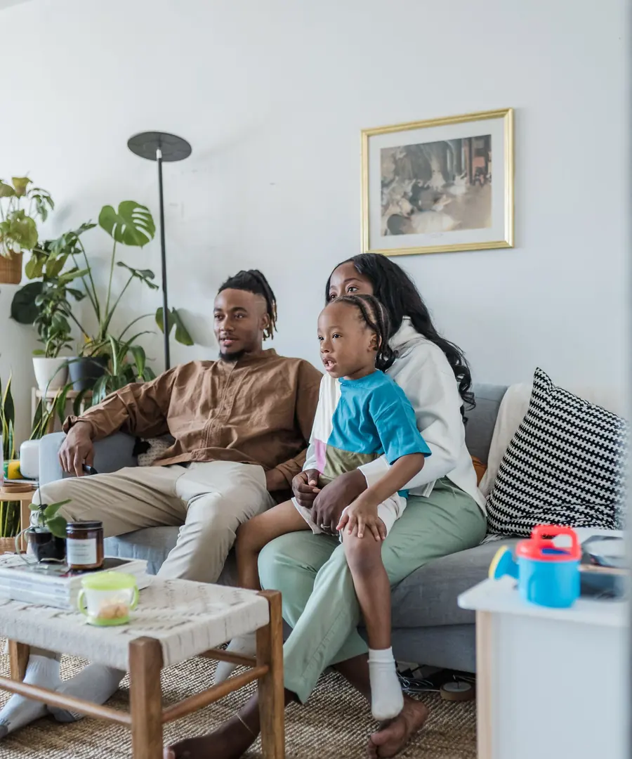 Família reunida na sala assistindo à grade do IPTV Qualidade